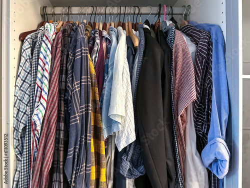 Wardrobe with shirts hanging on row in home