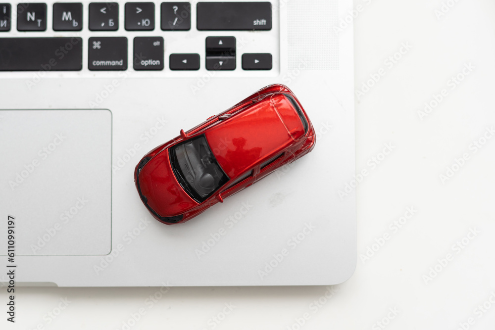 Car model on notebook and mouse on wooden desk. About car business concept such as transportation, rental, sell and buy