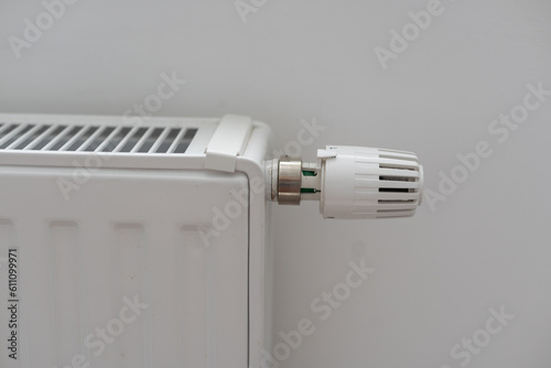 Thermostatic radiator valve. A valve for regulating the radiator temperature. Controling the temperature of a room. Thermostat. White radioator valve set to highest temperature.