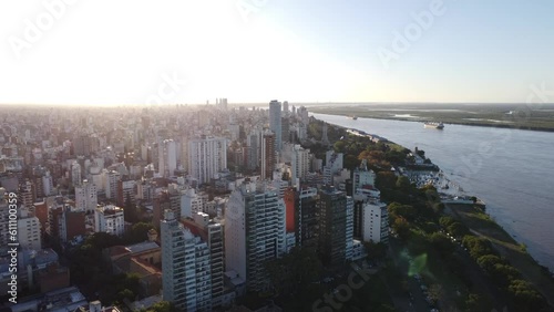 Ciudad de Rosario en Santa Fe, Argentina un día soleado con vista hacia el centro de la ciudad y el Río Paraná volando por sobre el Parque Urquiza photo