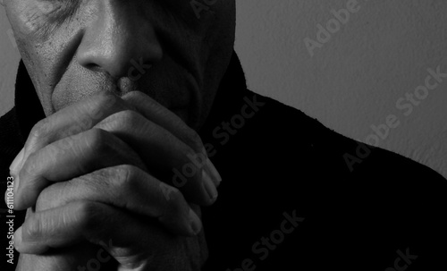 man praying to god with hands together Caribbean man praying on black background with people stock photos stock photo	