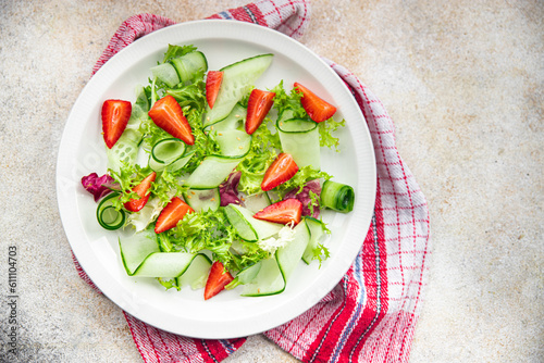 strawberry salad cucumber, lettuce healthy meal food snack on the table copy space food background rustic top view 