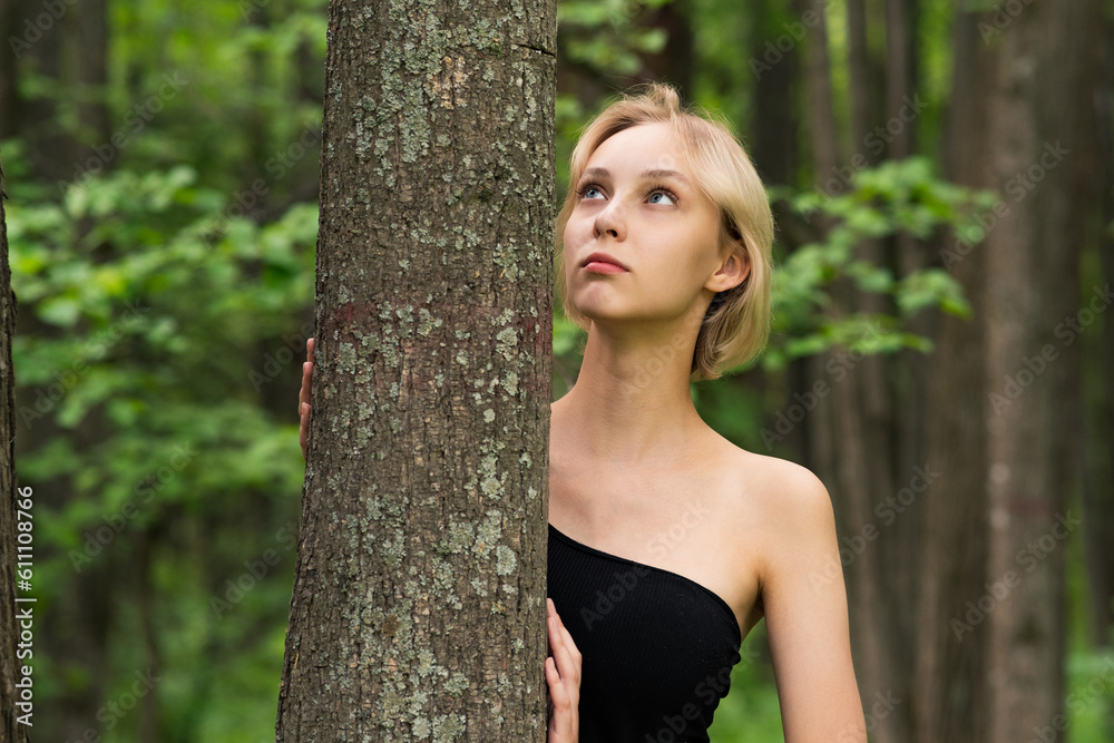 beautiful girl next to the tree in the forest beautiful girl next to the tree in the forest