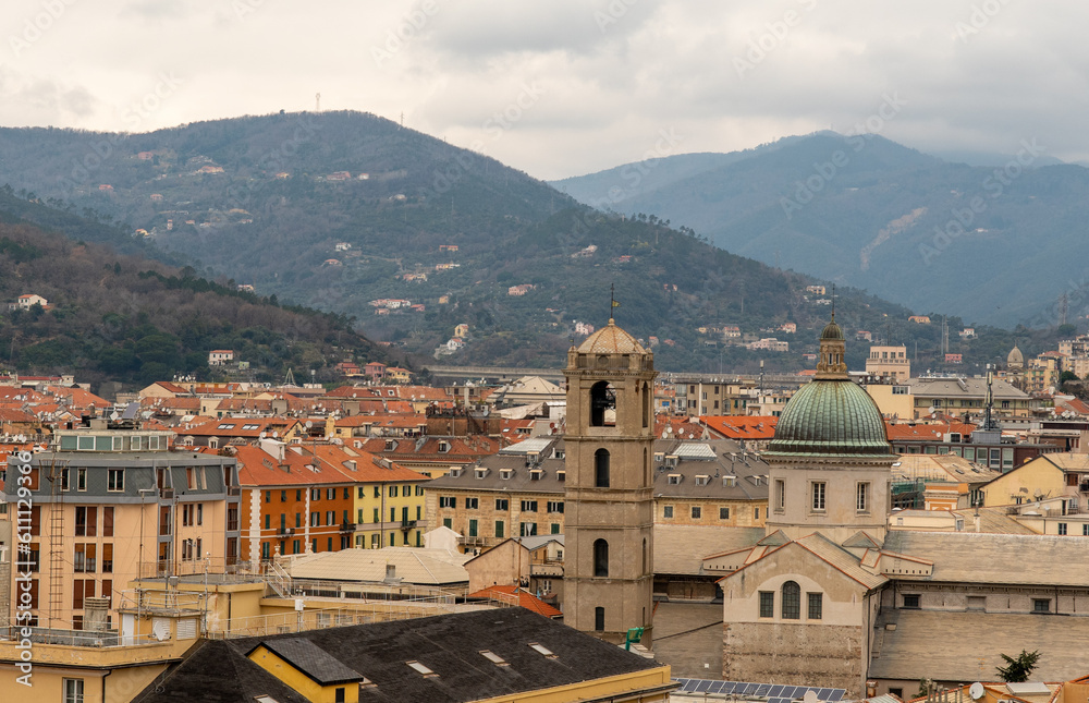 Rooftop cityscape with the bell tower and the dome of the Cathedral of Santa Maria Assunta (1605) and the Appennino Ligure range in a cloudy day, Savona, Liguria, Italy