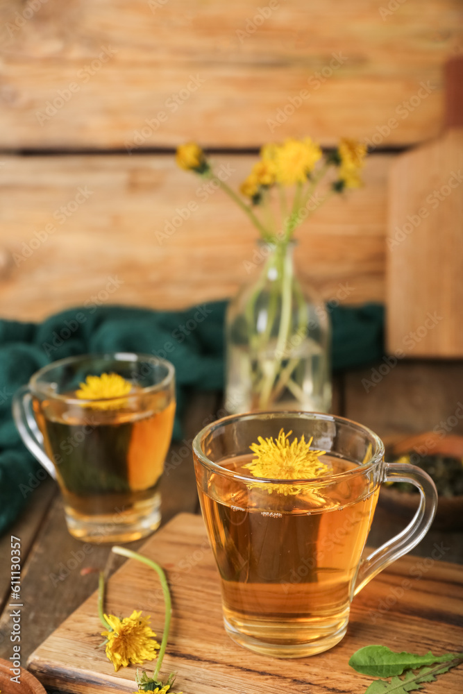 Board with glass cups of healthy dandelion tea on wooden table Board with glass cups of healthy dandelion tea on wooden table