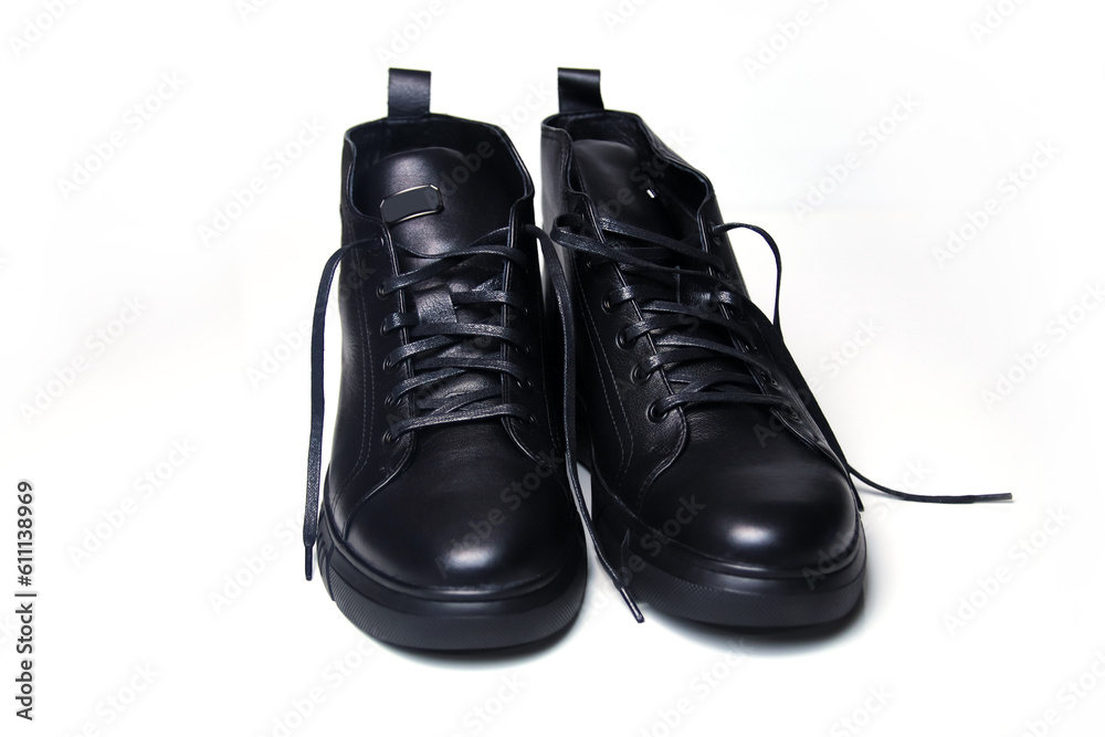 black leather men's shoes on a clean white background. These stylish ankle boots are crafted from high-quality leather. The closed-up shot showcases the fine details and craftsmanship. Out of focus