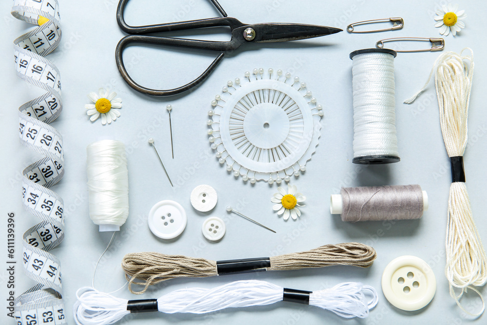 Set of different embroidery supplies on grey background Set of different embroidery supplies on grey background