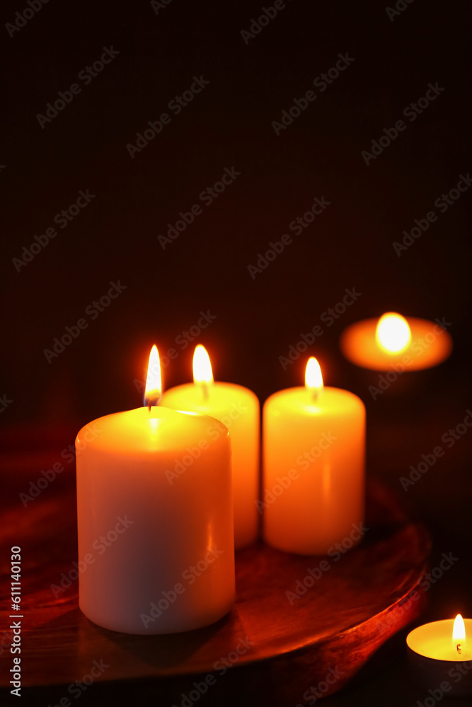 Beautiful burning candles on black background