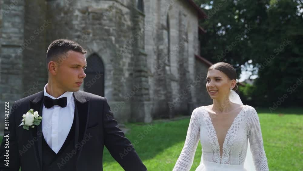 Newlyweds portrait. Lovely Caucasian bride, groom walking near old castle. Newlyweds portrait. Lovely Caucasian bride, groom walking near old castle.