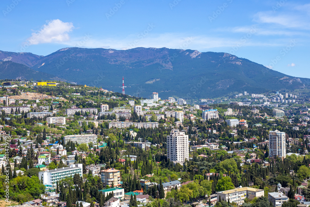 city in the mountains. Tall houses surrounded by cypress trees against the backdrop of mountains