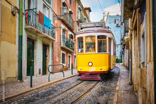 Famous vintage yellow tram 28 in the narrow streets of Alfama district in Lisbon, Portugal - symbol of Lisbon, famous popular travel destination and tourist attraction © Dmitry Rukhlenko