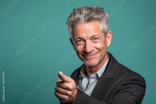 Headshot portrait photography of a tender mature man pointing at oneself against a mint green background. With generative AI technology