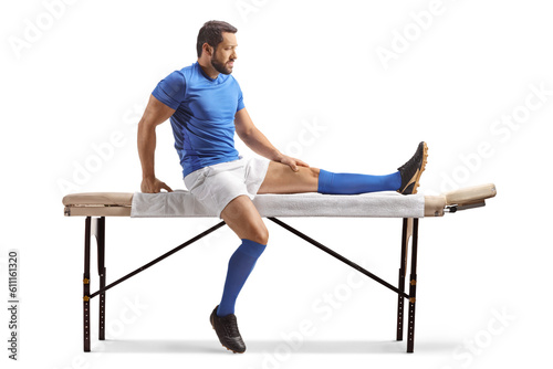 Football player sitting on a massage bed