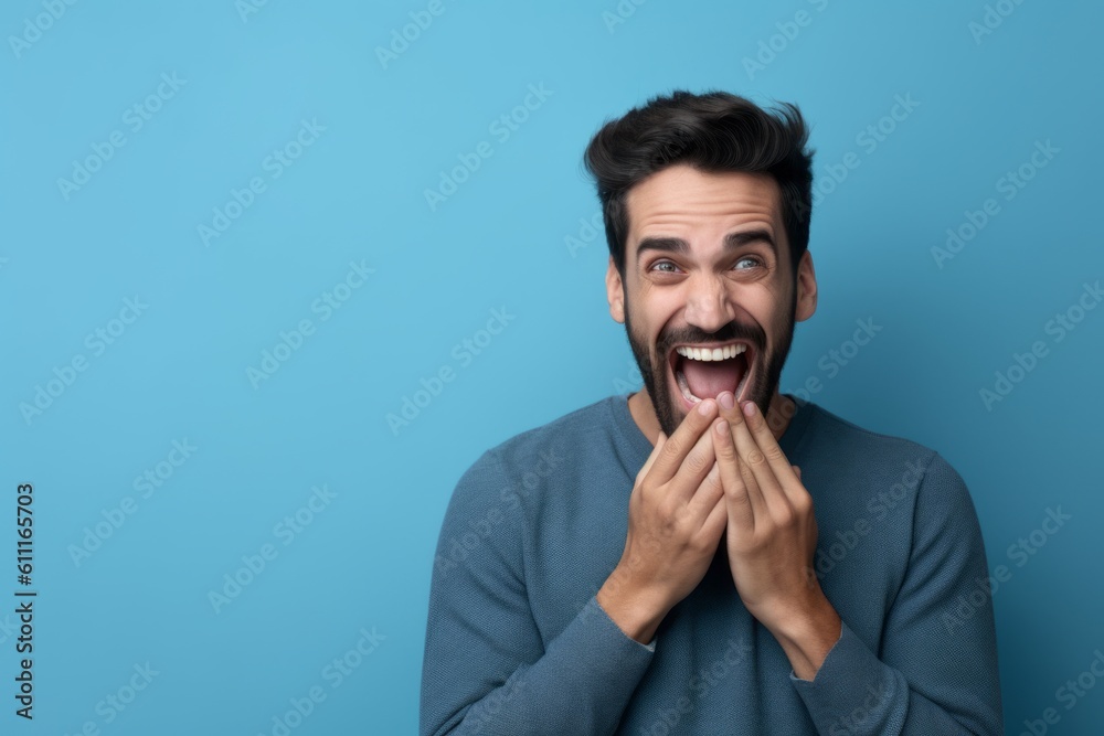 Medium shot portrait photography of a glad boy in his 30s placing the hand over the mouth in a laughter gesture against a periwinkle blue background. With generative AI technology