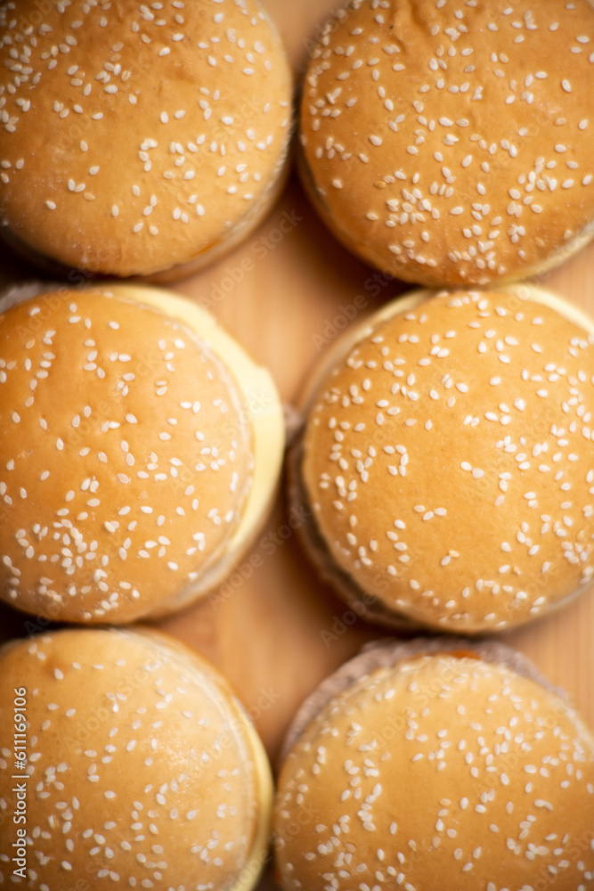 Close-up of cheeseburgers or hamburgers on a wooden background. Food background. Buns with sesame.