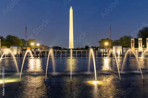 Washington Monument lit up at twilight with a fountain in the foreground