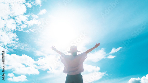 Woman rise hand up to amazing blue sky feel never give up and freedom.