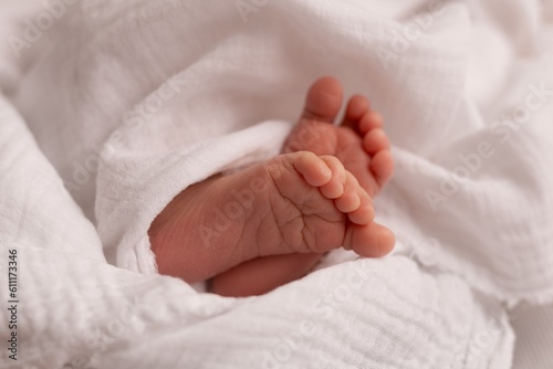 newborn photography details: newborn tiny feet in white muslin blanket 
