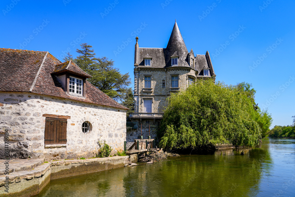 Stately home with a round tower built on a wall over the river Loing in the medieval town of Moret-sur-Loing in Seine et Marne, France