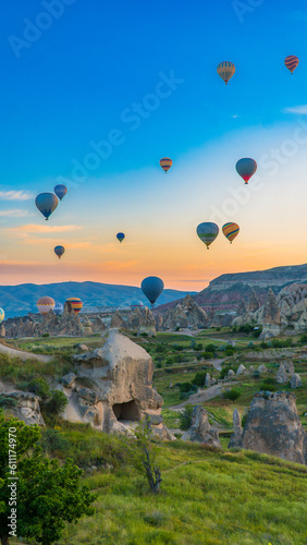 Cappadocia Turkey. Hot air balloons flying over fairy chimneys at sunrise in Cappadocia. Travel to Turkey. Touristic landmarks of Turkiye. Selective focus included.