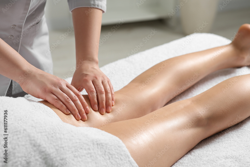 Woman receiving leg massage in spa salon, closeup