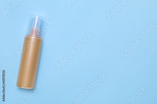 Bottle of face cleansing product on light blue background  top view. Space for text