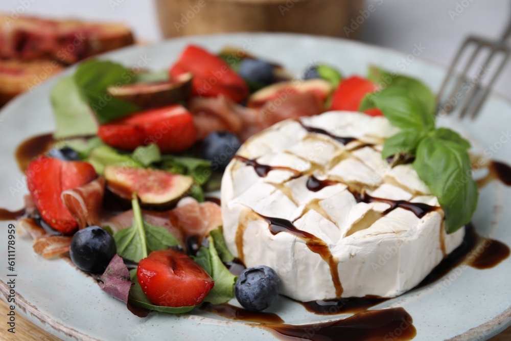 Delicious salad with brie cheese, berries and balsamic vinegar on plate, closeup Delicious salad with brie cheese, berries and balsamic vinegar on plate, closeup