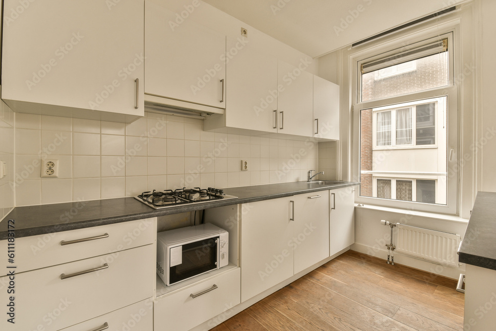 a kitchen with white cabinets and black counter tops on the island in front of the stove, which has been used for cooking a kitchen with white cabinets and black counter tops on the island in front of the stove, which has been used for cooking