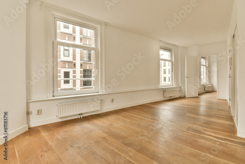 an empty room with wood flooring and large windows in the center of the room is white walls  wooden floors