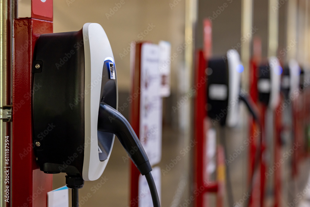 EV charging an electric car. Power supply for electric car charging. Socket for electric car battery charger. EV car charging station in car parking. Nature energy, Clean energy, Green eco concept. EV charging an electric car. Power supply for electric car charging. Socket for electric car battery charger. EV car charging station in car parking. Nature energy, Clean energy, Green eco concept.
