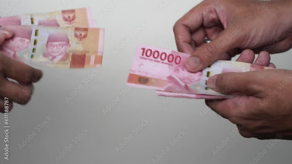 Someone manually counted one hundred thousand rupiah Someone manually counted one hundred thousand rupiah
