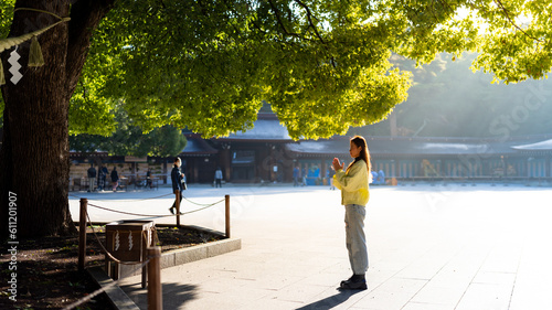 Photography Young Asian woman praying in traditional Meiji Jingu Shrine in Tokyo city, Japan