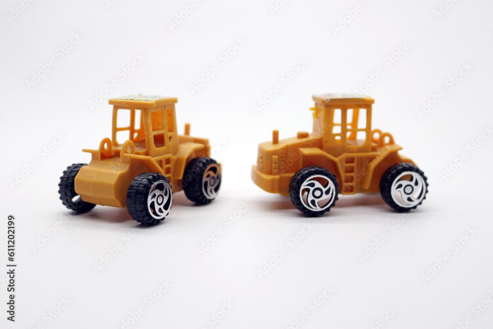 Fototapeta premium Two clean yellow toy trucks