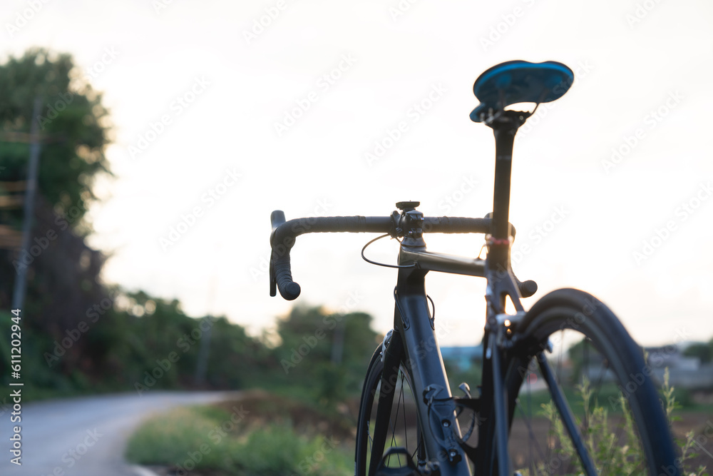 Road bike parked on a beautiful road sunset, warm light with copy space. Road bike parked on a beautiful road sunset, warm light with copy space.