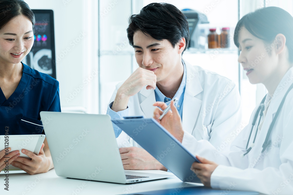 Doctors having a meeting while looking at electronic tablets and materials Doctors having a meeting while looking at electronic tablets and materials