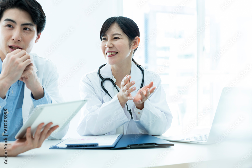 Doctors having a meeting while looking at electronic tablets and materials Doctors having a meeting while looking at electronic tablets and materials