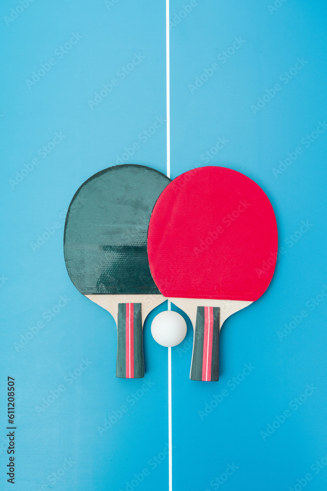 Two table tennis or ping pong rackets and balls on a blue table Two table tennis or ping pong rackets and balls on a blue table