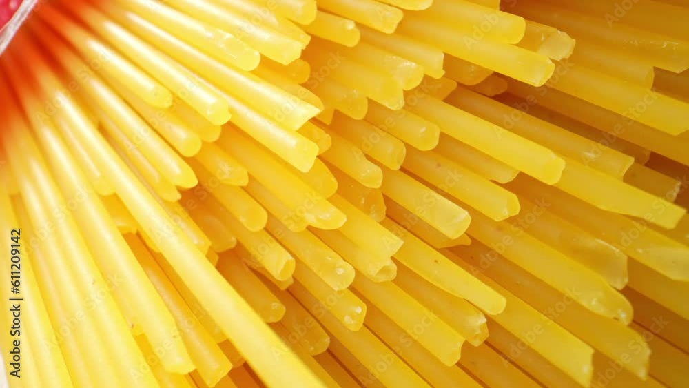 Coarser, thicker dry spaghetti noodles stand tall, showcasing their rough texture and sturdy structure under the macro lens. Raw material and food concept. Food pattern. Spaghetti background. 4K HDR
