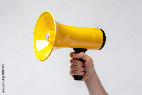The hand holds a yellow megaphone on white background. Announcement concept. Shout It Out