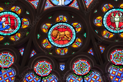 St. Denis Basilica Paris France. Colorful zodiac symbols depicted in a stained glass window in a medieval cathedral including Leo  Virgo  Cancer and geometric designs
