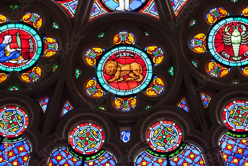 St. Denis Basilica Paris France. Colorful zodiac symbols depicted in a stained glass window in a medieval cathedral including Leo, Virgo, Cancer and geometric designs