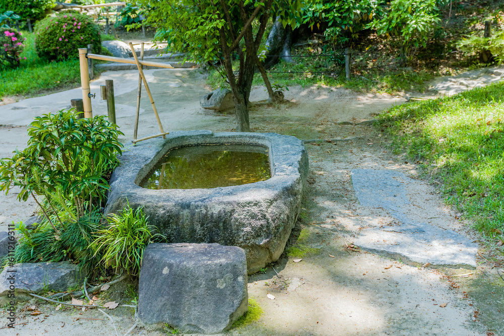 Stone water basin with bamboo pluming in Japanese garden. Stone water basin with bamboo pluming in Japanese garden.