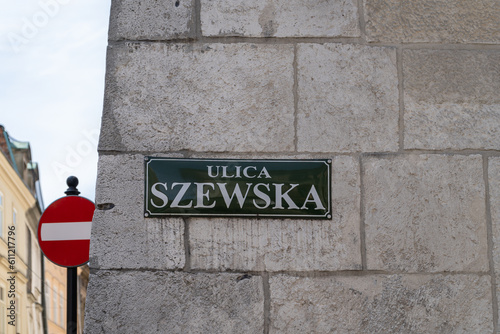 Szewska street name sign in the Old Town district of Krakow, Poland. Information plate on building wall in Kraków. One of the main historic promenades of Cracow, that begins at the Main Square Market photo