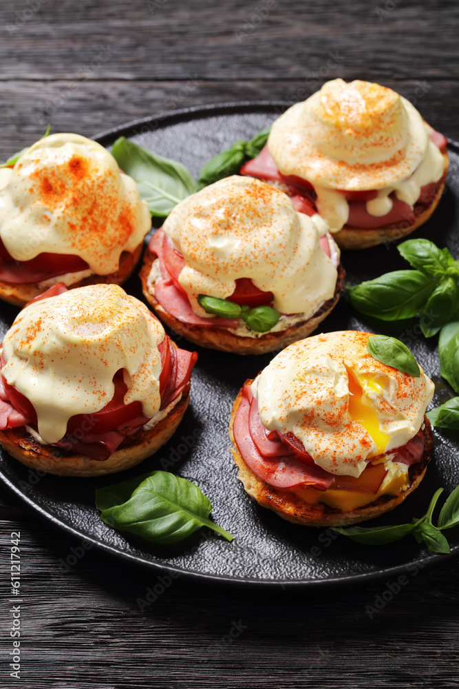 Eggs Benedict on black plate, top view Eggs Benedict on black plate, top view