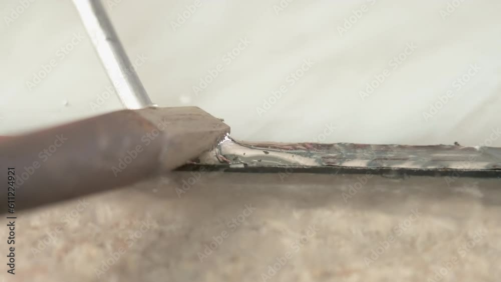 Soldering of stained glass. Men processes the copper tape of a stained glass panel. He use tin