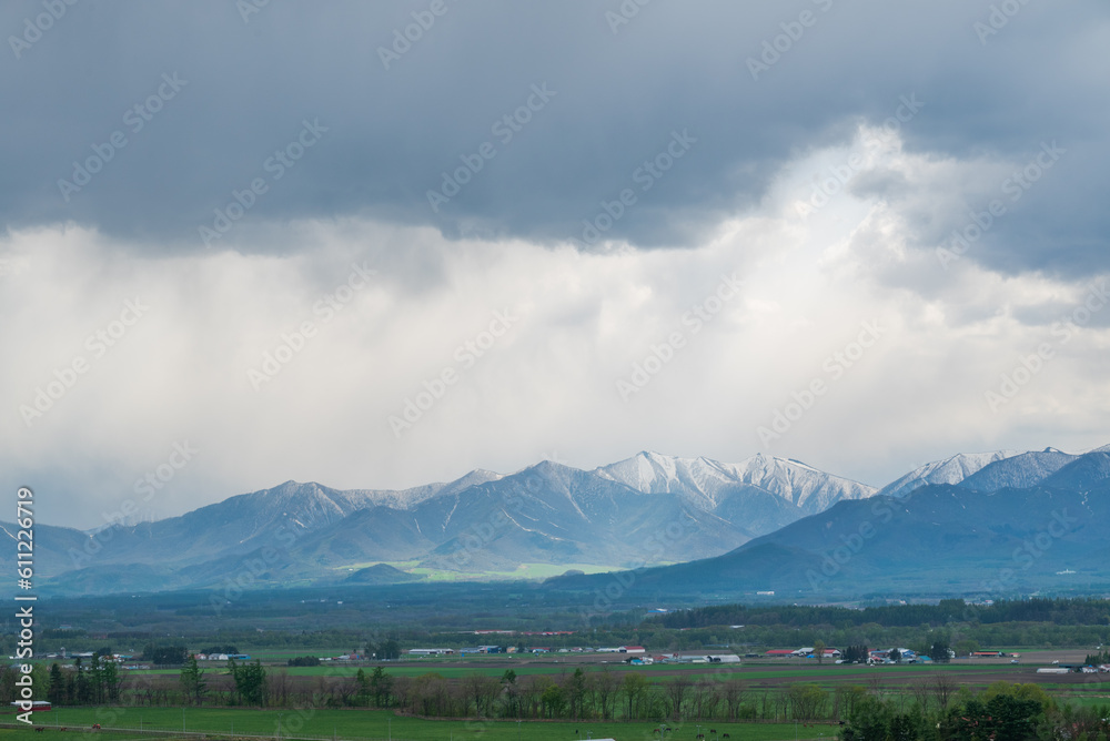 Fototapeta premium 十勝清水四景美蔓パノラマパーク から十勝平野の農村風景とバックの雄大な日高山脈の絶景
