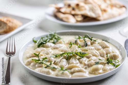 Creamy gnocchi with four types of cheese and ruccola on top photo