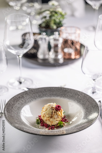 Fancy wedding dessert from white chocolate, almonds and coconut with raspberries on a deep plate