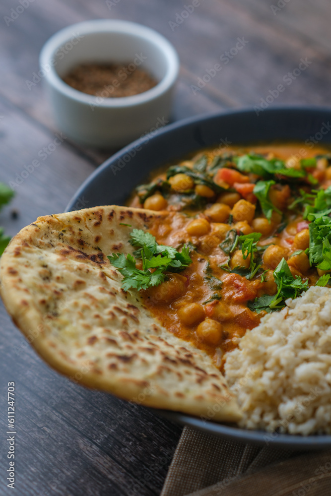 Vegan Chickpea curry on a dark background. Close-up. Healthy vegetarian food concept. Traditional Indian food concept. Vegan Chickpea curry on a dark background. Close-up. Healthy vegetarian food concept. Traditional Indian food concept.