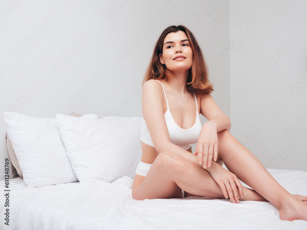 Attractive and relaxed seductive young woman with slim body wearing white underwear. Sexy smiling model lying on sheets in the bedroom at home in the early morning in lingerie. Happy female in bed Attractive and relaxed seductive young woman with slim body wearing white underwear. Sexy smiling model lying on sheets in the bedroom at home in the early morning in lingerie. Happy female in bed
